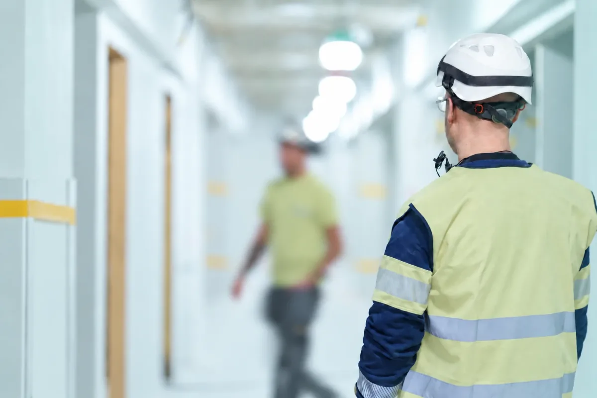 Tekniker i varselväst i en korridor på arbetsplatsen
